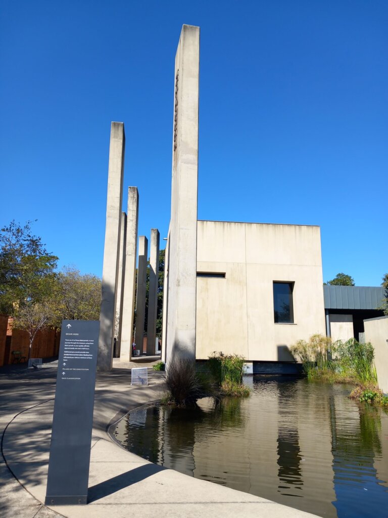 This image shows some of the seven pillars of the constitution built at the entrance to the Apartheid Museum