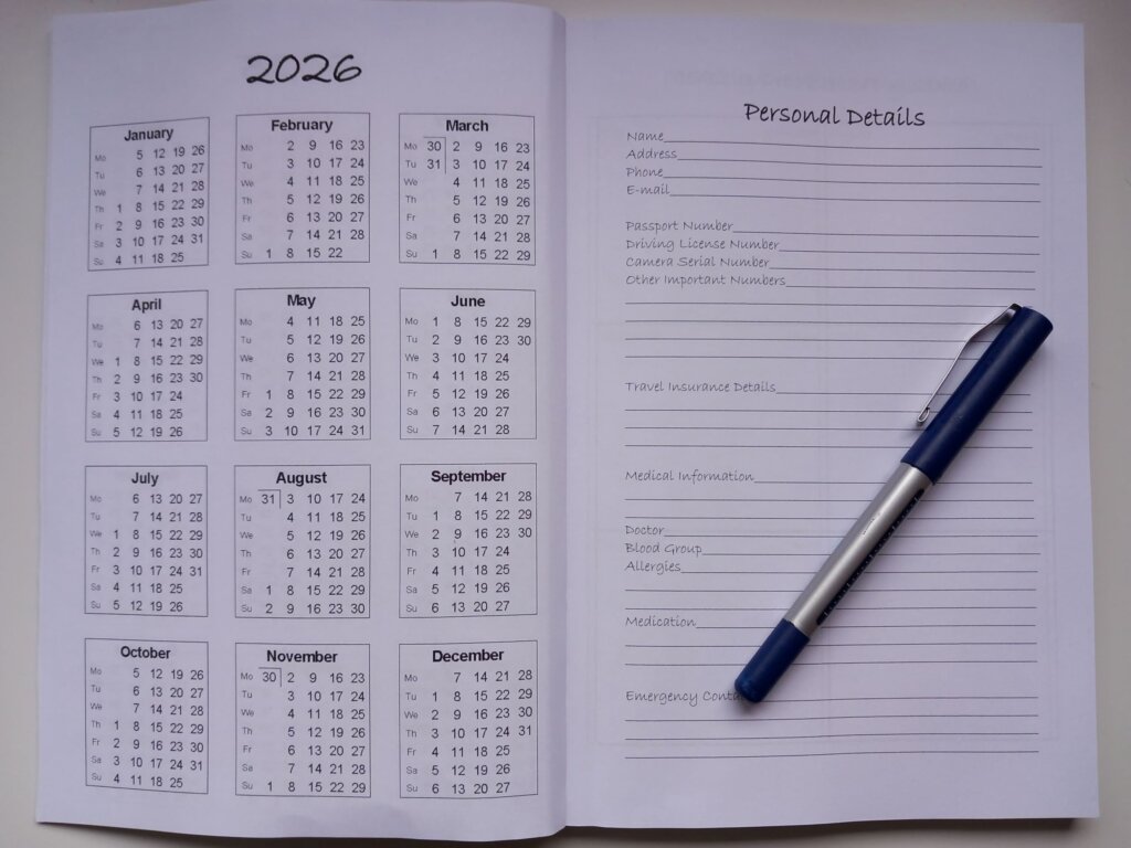 This photo shows the personal details page of the 2025 travel diary with a pen lying diagonally across it