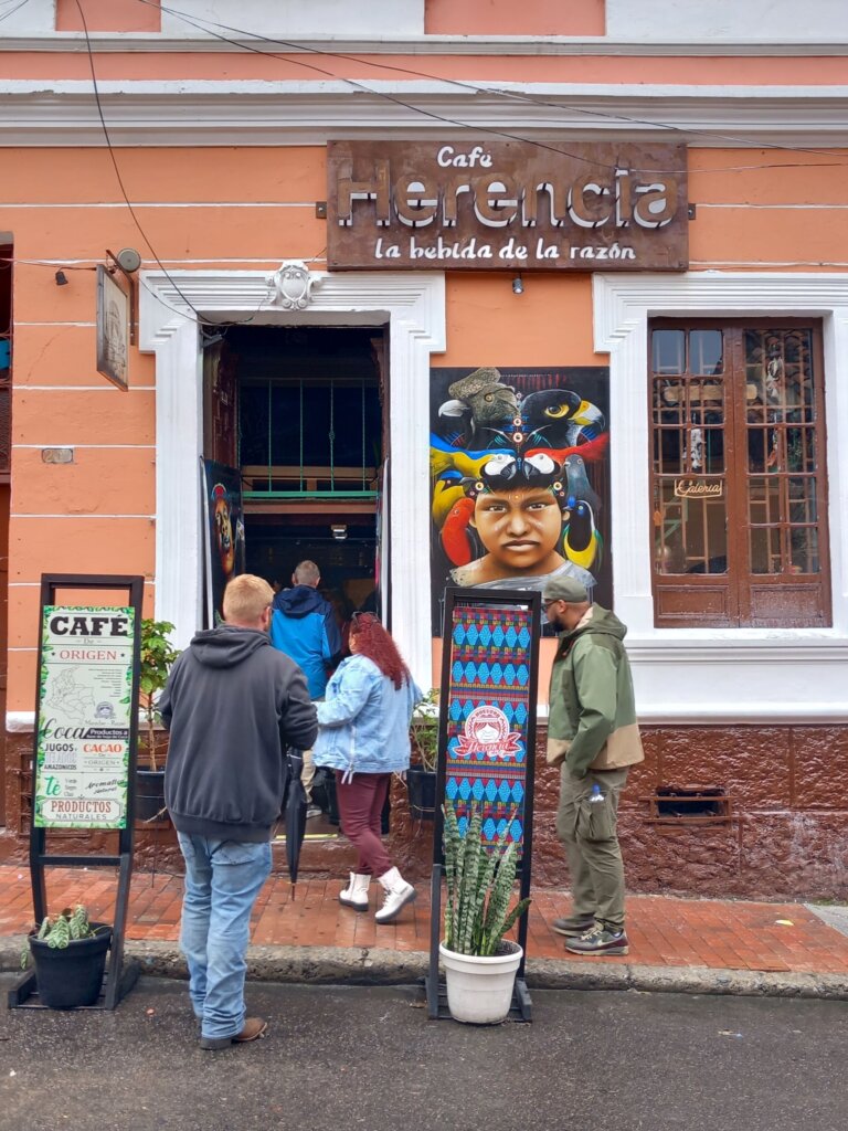 This image shows our group entering Cafe Herencia, a terracotta-coloured building with art displayed outside