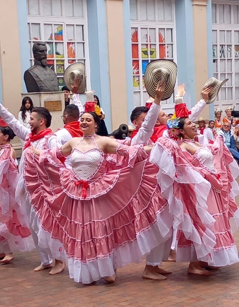 This image shows dancers dressed in pink and white costumes