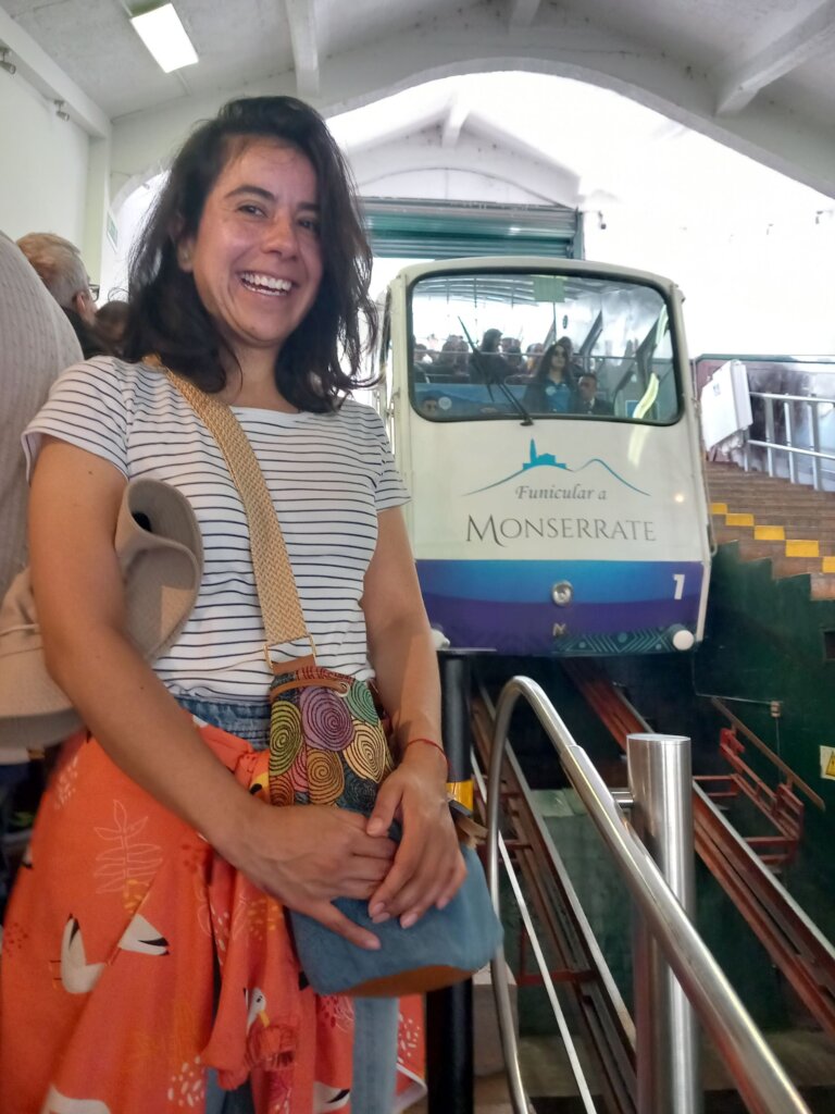 This image shows our tour guide, Gina, smiling as she stands besides a descending funicular