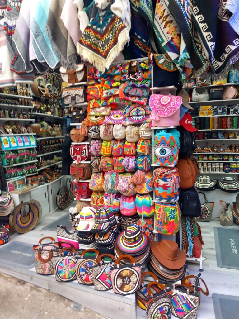 This image shows a stall full of brightly coloured bags and hats