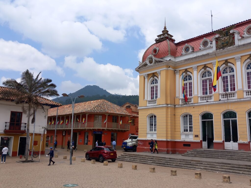 This image shows the French colonial town hall in Zipaquira's main square with the mountains behind